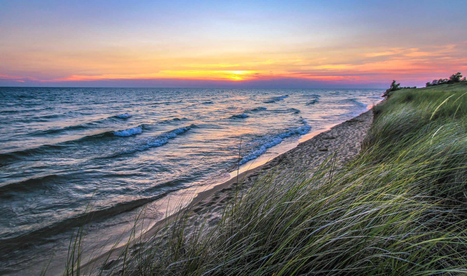 Sunset landscape as waves roll in on the beautiful coast of Lake Michigan at Hoffmaster State Park near Muskegon.
